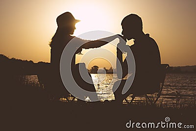Silhouette of appointment of young couples in love to leave on a picnic out of town at dawn Stock Photo