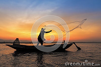 Silhouette of asian fisherman on wooden boat in action Stock Photo