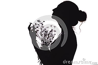 Silhouette of a beautiful girl with a bouquet of dried flowers, face profile of a young woman looking upwards on a white isolated Stock Photo