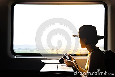 A silhouette of beautiful hipster asian woman traveling on the train. Sitting Stock Photo