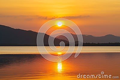 Silhouette, beautiful landscape with sunset at coast of the lake in summer. Nature twilight time, reflection, orange sky and Stock Photo