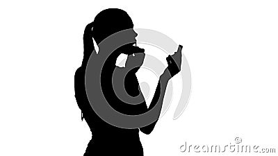 Silhouette Beautiful woman, dyes her lips lipstick pink, looking in the mirror. Stock Photo