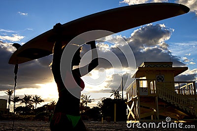 Silhouette Beautiful woman holding a Surfboard Stock Photo