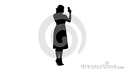 Silhouette Beauty woman looking at herself in her smartphone fixing her hair. Stock Photo