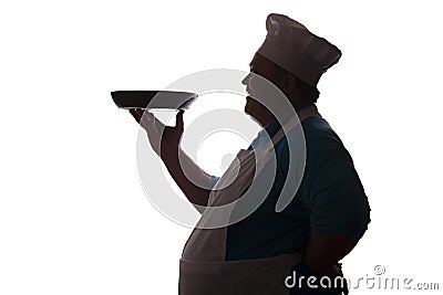 Silhouette of a big-bellied happy chef carrying a dish in pan on his hand on a white isolated background, good-natured man`s Stock Photo