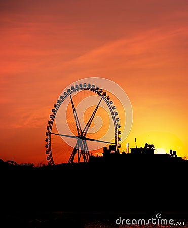 Silhouette of Big Ferris Wheel agaisnt the Sunset Stock Photo