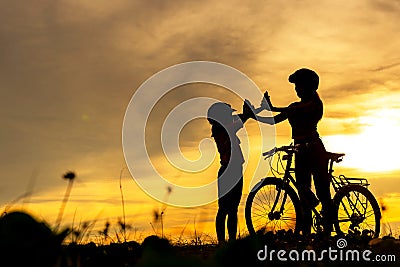 Silhouette biker lovely family raise give me five at sunset for relax and freedom. Stock Photo