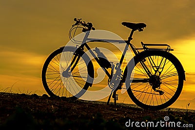 Silhouette biker at sunset over the beach. Stock Photo