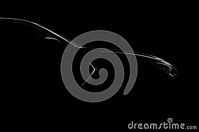 Silhouette of black sports car with headlights on black background Stock Photo