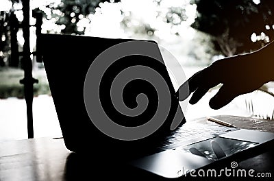 silhouette black and white of anonymous hacker typing on keyboard of laptop for remotely hacking and receiving personal Stock Photo