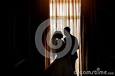 Silhouette of a bride and groom on the background of a window wi Stock Photo