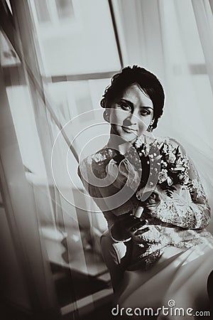 Silhouette of the bride weared in dress and veil with a bouquet Stock Photo