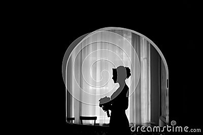 Silhouette of a bride at the window Stock Photo