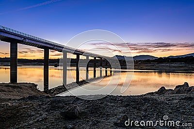 Silhouette Of Bridge Over lage at sunset Stock Photo