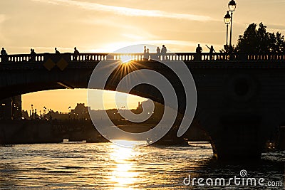 Silhouette of bridge Pont au Change with people over seine river at sunset in Paris, france Stock Photo