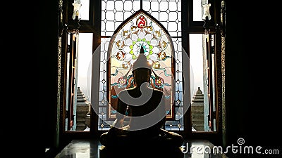 Silhouette buddha statue has flower and sun pattern stained gla Stock Photo