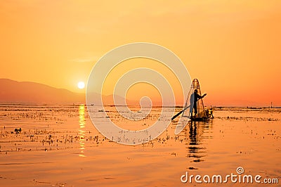 Silhouette of a Burmese fisherman on bamboo boat at sunset. Inle lake, Myanmar Burma, travel destination Editorial Stock Photo