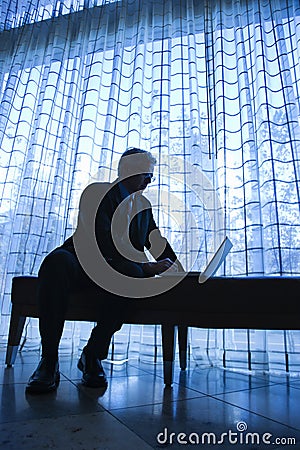 Silhouette of businessman and laptop. Stock Photo