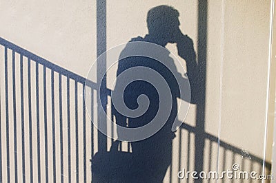 Shadow Of Businessman Standing and talking by smartphone. Stock Photo