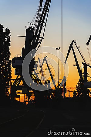 Silhouette of of cargo cranes. Port wharf landscape. Bright sunset, bright sky Stock Photo