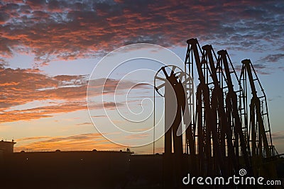 Silhouette cargo manifolds of the oil terminal in the sea port at sunset. Stock Photo