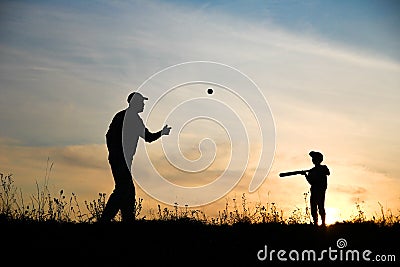 silhouette child with parent playing baseball concept Stock Photo