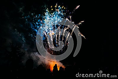 Silhouette Child on shoulders watching colourful fireworks on bonfire night. Stock Photo