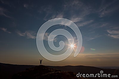 Silhouette of a child at sunset against the sky. At the edge of the earth. very beautiful sunset in the mountains Stock Photo