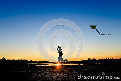 Silhouette of children flying a kite at sunset Stock Photo