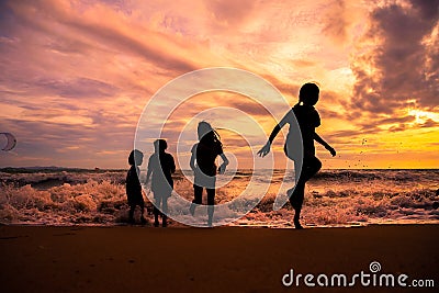 Silhouette children group enjoy playing on beach Stock Photo