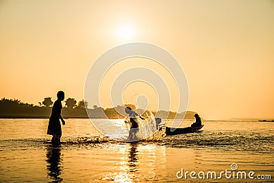 Silhouette of children playing water with friend Editorial Stock Photo