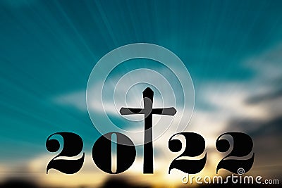 Silhouette of Christian cross with 2022 years at sunrise background. Concept of Christians new year 2022.Welcome merry Christmas Stock Photo