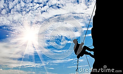 Silhouette climber climbing a mountain Stock Photo