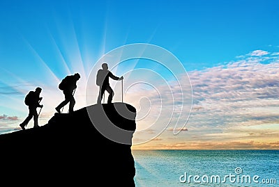 Silhouette climbers ascending to top of mountain Stock Photo