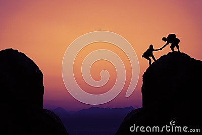 Silhouette of climbing people in mountains as symbol for team sp Stock Photo