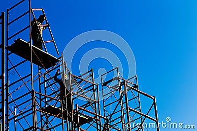 Silhouette of construction workers against sky on scaffolding wi Editorial Stock Photo