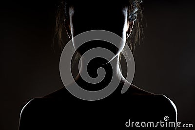Silhouette contour of a beautiful brunette girl. Side lit studio portrait on dark background Stock Photo