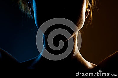 Silhouette contour of a beautiful brunette girl. Side lit studio portrait on dark background Stock Photo