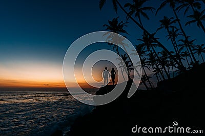 Silhouette of a couple in love on the beach. Man and woman at sunset. Honeymoon on the Islands. Man and woman meet sunset. Happy Stock Photo