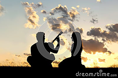 Silhouette of Couple Playing Guitar at Sunset Stock Photo