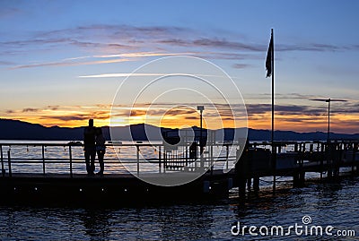 Silhouette couple watching sunset at lake Editorial Stock Photo