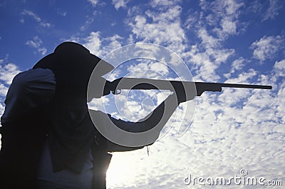 Silhouette of Cowboy aiming rifle Editorial Stock Photo