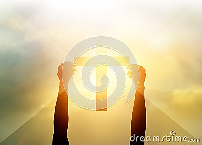 Silhouette the cross in hands, religion symbol in light and landscape Stock Photo