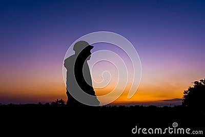 Silhouette dark young man wearing a hat standing emotions with evening Twilight sky with cloud in the winter season at sunset Stock Photo