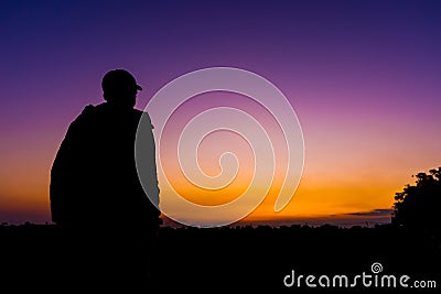 silhouette dark young man wearing a hat standing emotions with evening Twilight sky with cloud in the winter season at sunset Stock Photo