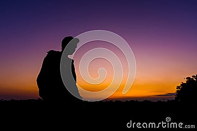 Silhouette dark young man wearing a hat standing emotions with evening Twilight sky with cloud in the winter season at sunset Stock Photo