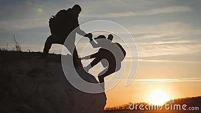 Silhouette de la main aidante entre deux grimpeurs deux randonneurs au sommet de la montagne, un homme aide une femme à grimper u banque de vidéos Silhouette de la main aidante entre deux grimpeurs deux randonneurs au sommet de la montagne, un homme aide une femme à grimper u banque de vidéos