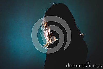 Silhouette of depress woman standing in the dark with light shin Stock Photo