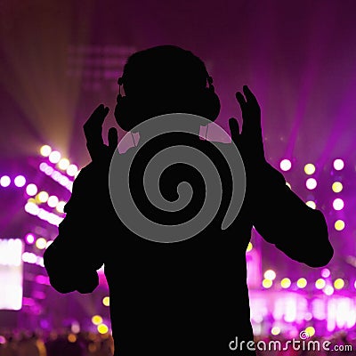 Silhouette of DJ wearing headphones and performing at a night club Stock Photo