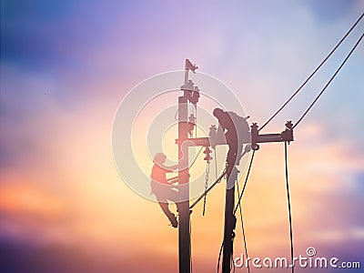 Silhouette electrical workers are installing high voltage system Stock Photo